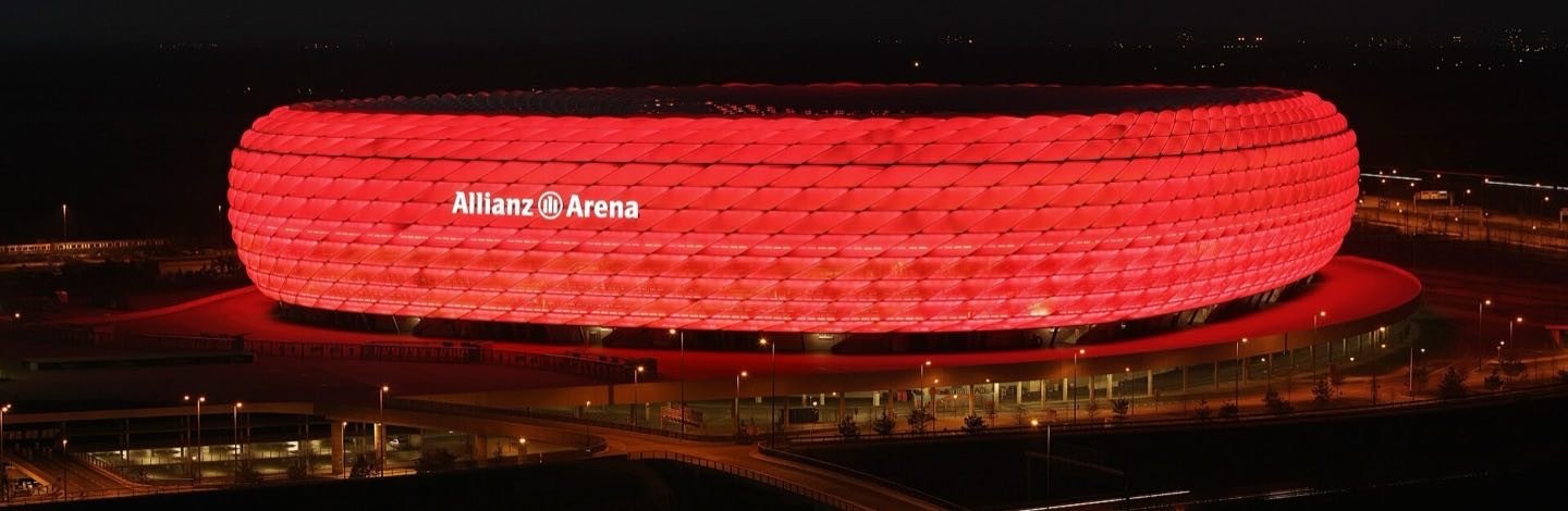 Modernes Fussballstadion bei Nacht, rot beleuchtet